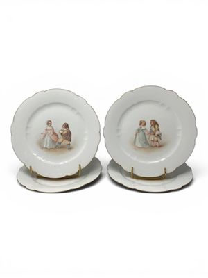 pair of porcelain plates with children on them on a white surface