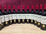six bouteilles de vin rouge sont alignées sur une planche en bois
