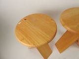 two small wooden stools sitting next to each other on a white surface