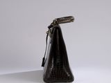 a brown crocodile skin purse with a long strap and a metal clasp