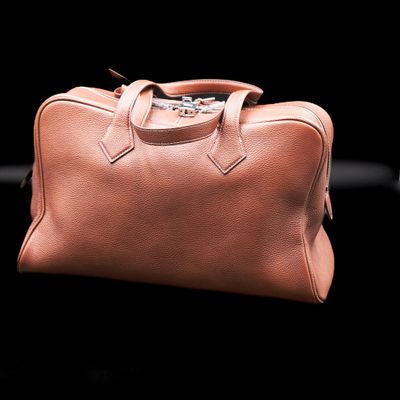 an image of a brown leather bag on a black background