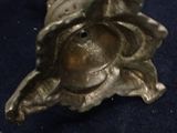 brass figurine of a woman holding a bird on a branch