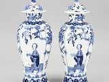 pair of blue and white vases with figures on them