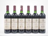 six bouteilles de vin sont alignées sur une surface blanche