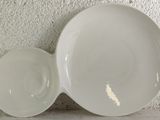 a white bowl and saucer sitting on a counter