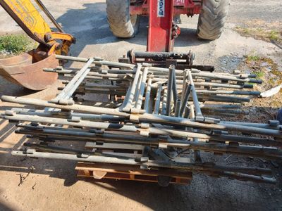 un tracteur garé à côté d'un tas de tuyaux
