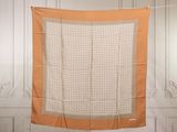 an orange and white square scarf hanging on a clothes line