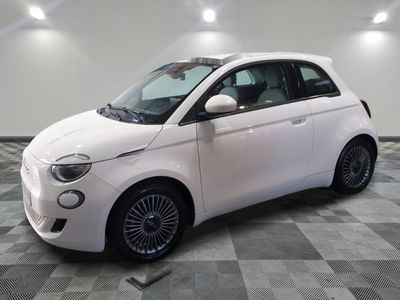 une petite voiture blanche garée sur un sol en damier