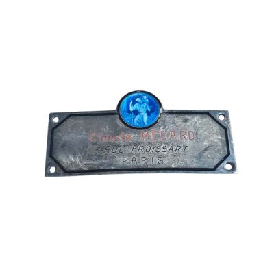 the plaque is made of metal and has a picture of a dog on it