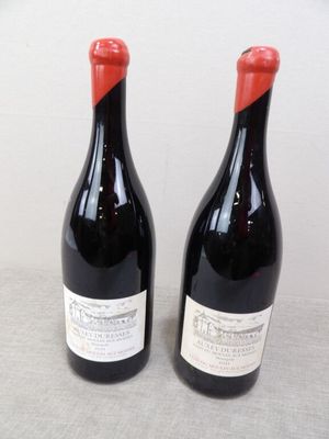 deux bouteilles de vin posées sur une table l'une à côté de l'autre