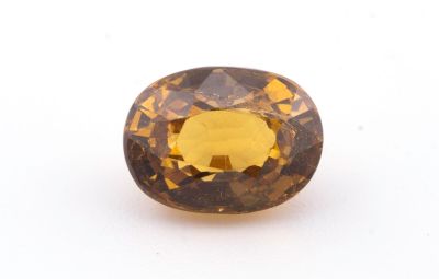 gros plan d'un diamant jaune sur une surface blanche