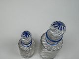 two salt and pepper shakers sitting on a white surface