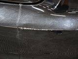 a close up of a car ' s front bumper with scratches on it