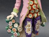 an image of a figurine of a man with flowers and a dog