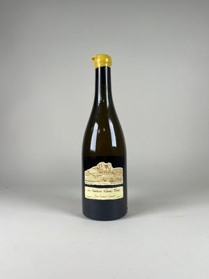une bouteille de vin posée sur une table blanche