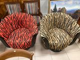 two zebra print chairs in a room with a painting on the wall