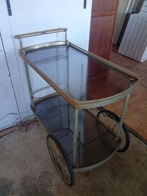 a metal cart with a glass top on the floor