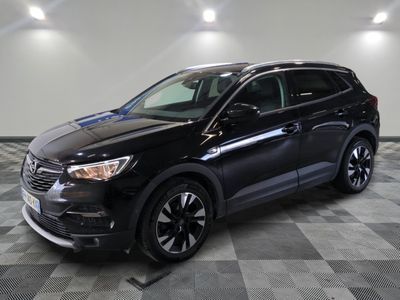 un 4x4 noir garé sur un sol en damier dans un garage