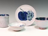 three cups and a plate on a white table