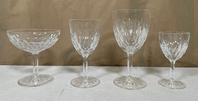 Quatre verres à vin sont alignés sur une table devant un mur.