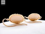 pair of gold tone earrings with pink stone in the middle