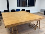 an empty meeting room with a wooden table and black chairs