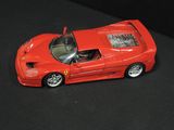 a red toy car that is sitting on a black surface