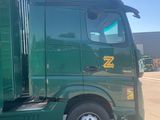 a green truck that is parked in a parking lot