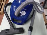 un aspirateur bleu posé sur une table