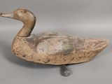 un petit canard en bois posé sur une table