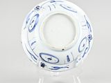 blue and white plate with a design on it on a clear stand