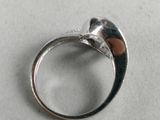 a silver ring with a diamond in it on a table