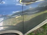 a close up of a car door with a reflection of the sky
