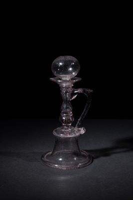 a glass candle holder with a glass ball on top of it