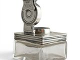 un objet en argent surmonté d'une pièce de monnaie