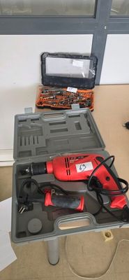 une boîte à outils contenant une perceuse et d'autres outils, posée sur une table
