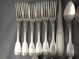 a lot of silver spoons and spoons on the table