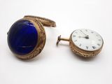 une montre-bracelet en or et une montre en lapis-lazuli posées l'une à côté de l'autre