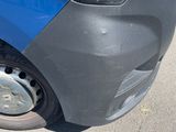 a close up of the front bumper of a blue van
