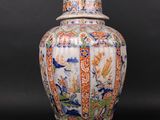 an oriental vase with a lamp on top of it on a black surface