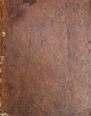 un vieux livre à la couverture rouillée posé sur une table