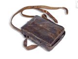 an old brown leather bag with a strap on a white background
