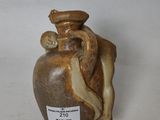 un vase en céramique sur lequel est représentée une femme tenant un bébé dans ses bras