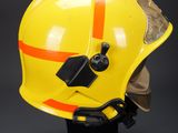 a close up of a yellow fireman ' s helmet on a stand