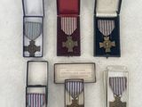 four medals and a medal in a case on a white surface