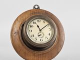 a wooden clock on a stand on a white background
