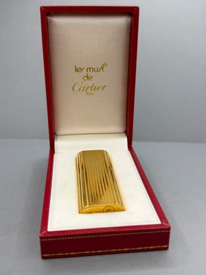 an image of a gold lighter in a red box on a table