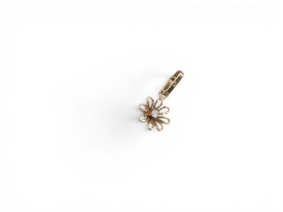 un petit pendentif en forme de fleur dorée sur fond blanc