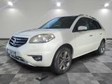 la voiture blanche est garée sur un sol en damier dans le garage