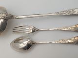 four spoons and a fork on a white table